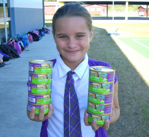 student holding cat food cans